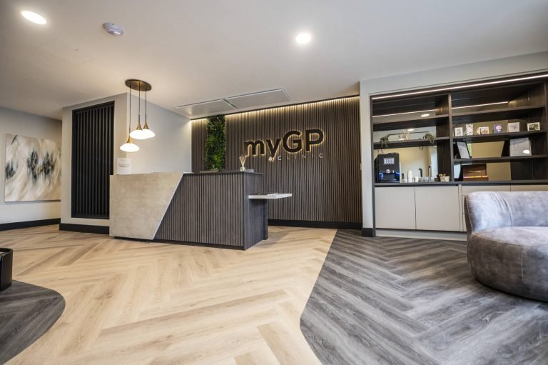 The reception area of the myGP Clinic in Wilmslow, with the brand name on a slatted timber wall