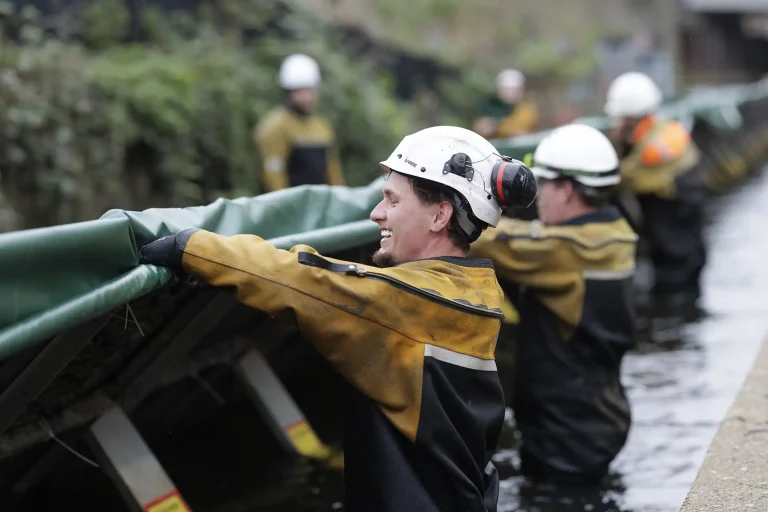 A team in waders installing a temporary frame dam across a watercourse